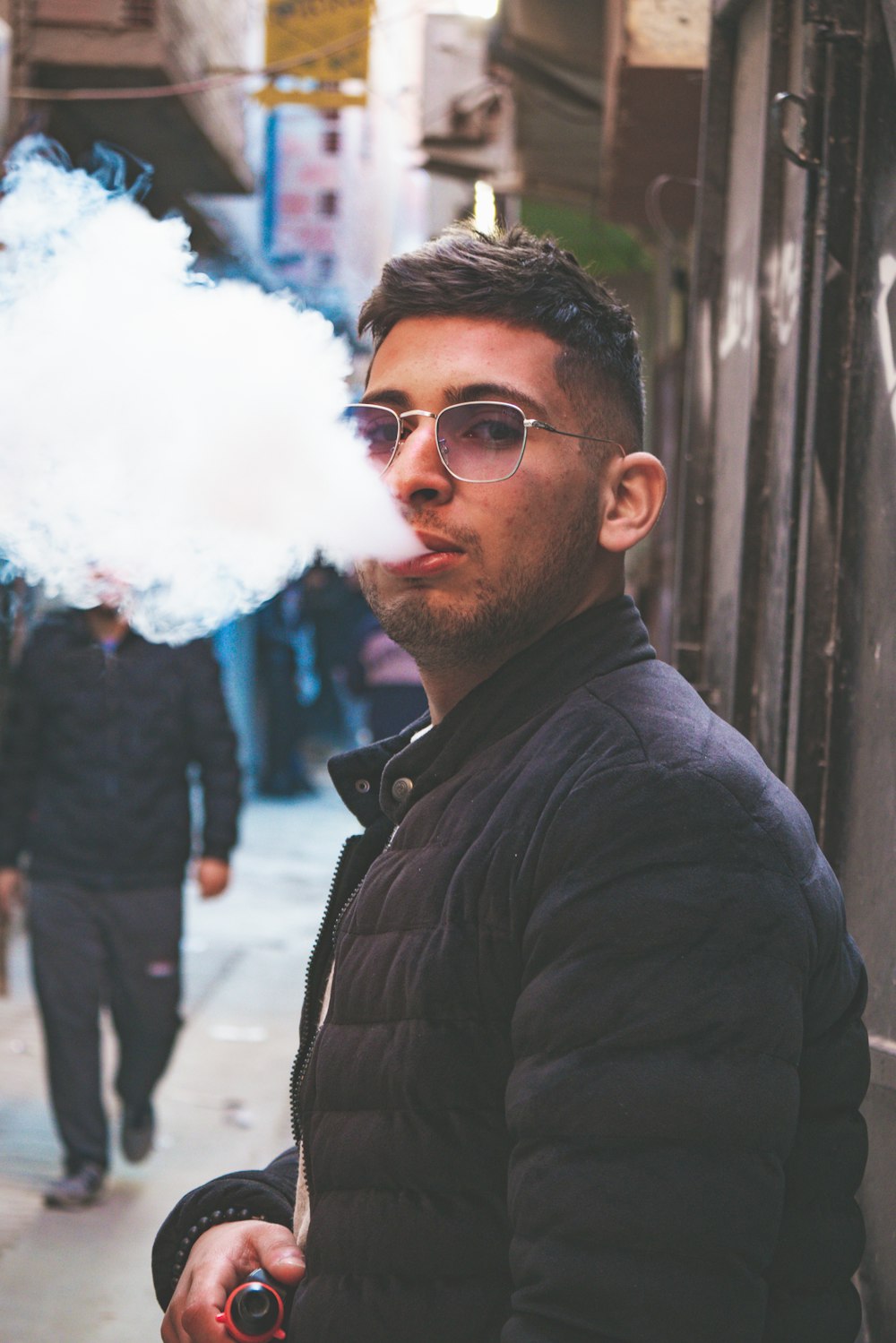 a man smoking a cigarette on a city street