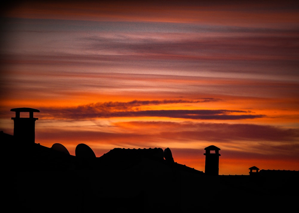 a red sky with some clouds and a clock tower