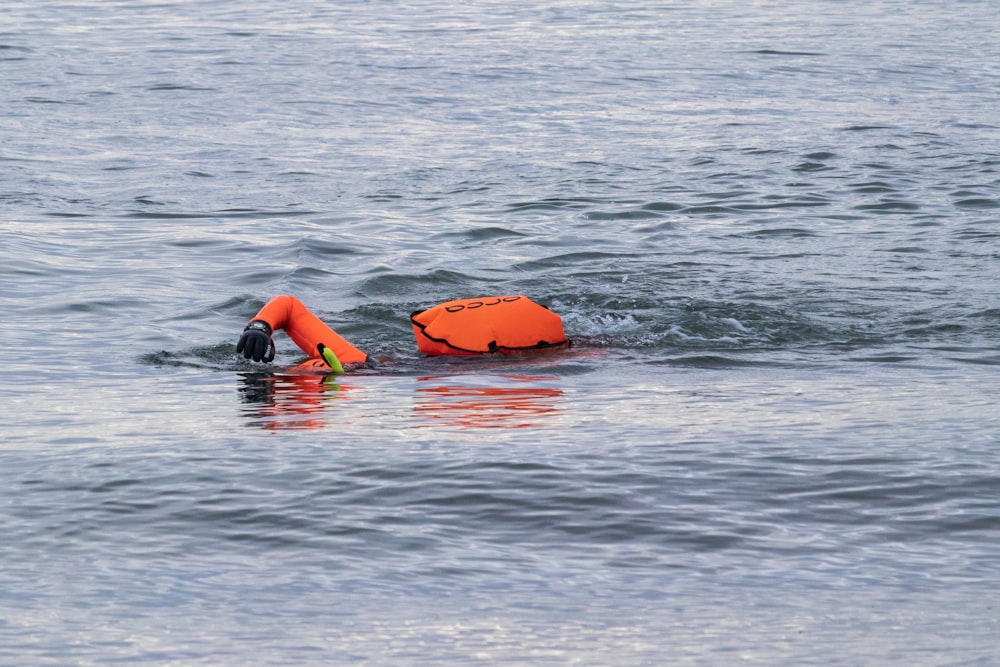 an orange life jacket floating on top of a body of water