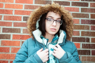 Close-up of a wool-lined hood and sturdy zipper on a dark green winter coat.