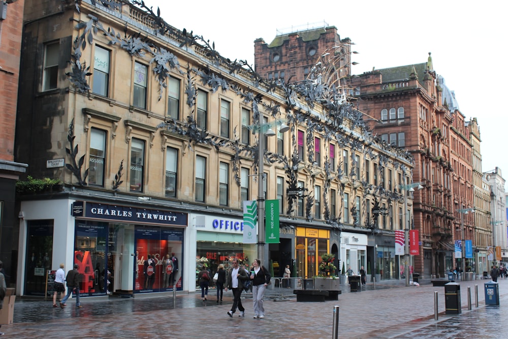 a group of people walking down a street next to tall buildings