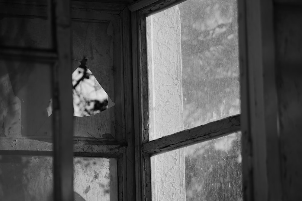 a black and white photo of a broken window