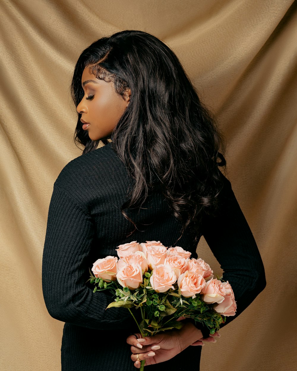 a woman holding a bouquet of roses in her hands