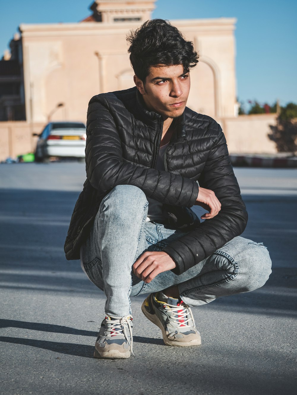 a man squatting down in the middle of a street