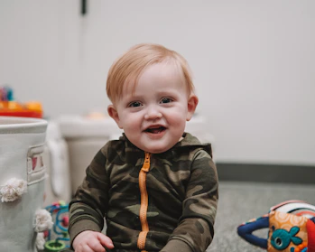 A cheerful child playing with colorful second-hand toys in a cozy room filled with soft pastel decorations.