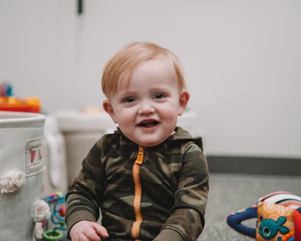 A warm therapy room with colorful toys and a child smiling during a session.