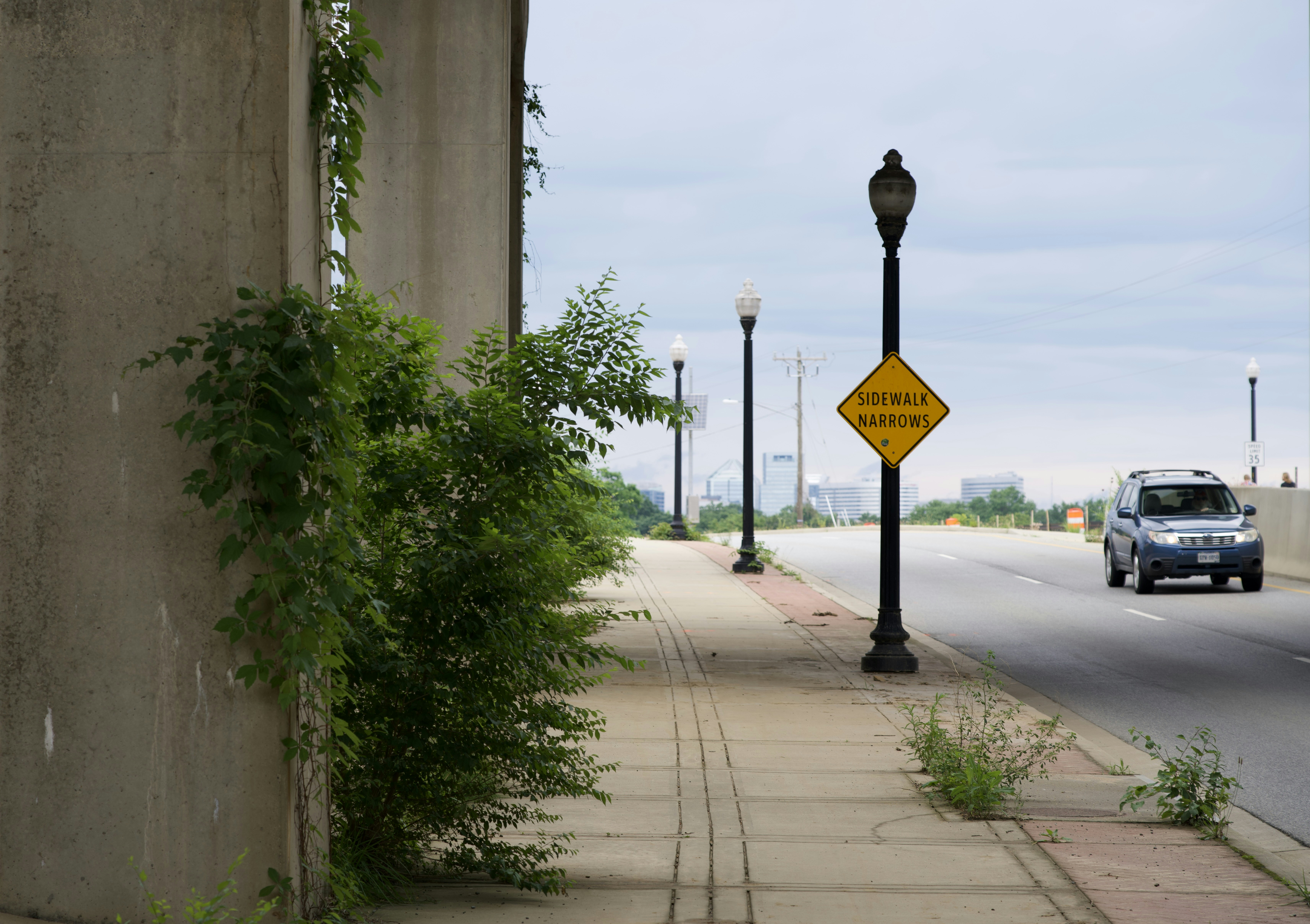 A yellow street sign sitting on the side of a road photo – Free Car ...