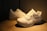 A pair of stylish men's sneakers displayed on a wooden surface with natural lighting.