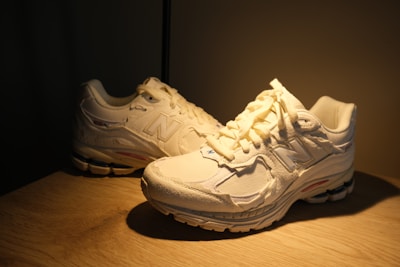 A close-up of a pair of running shoes on a wooden surface.