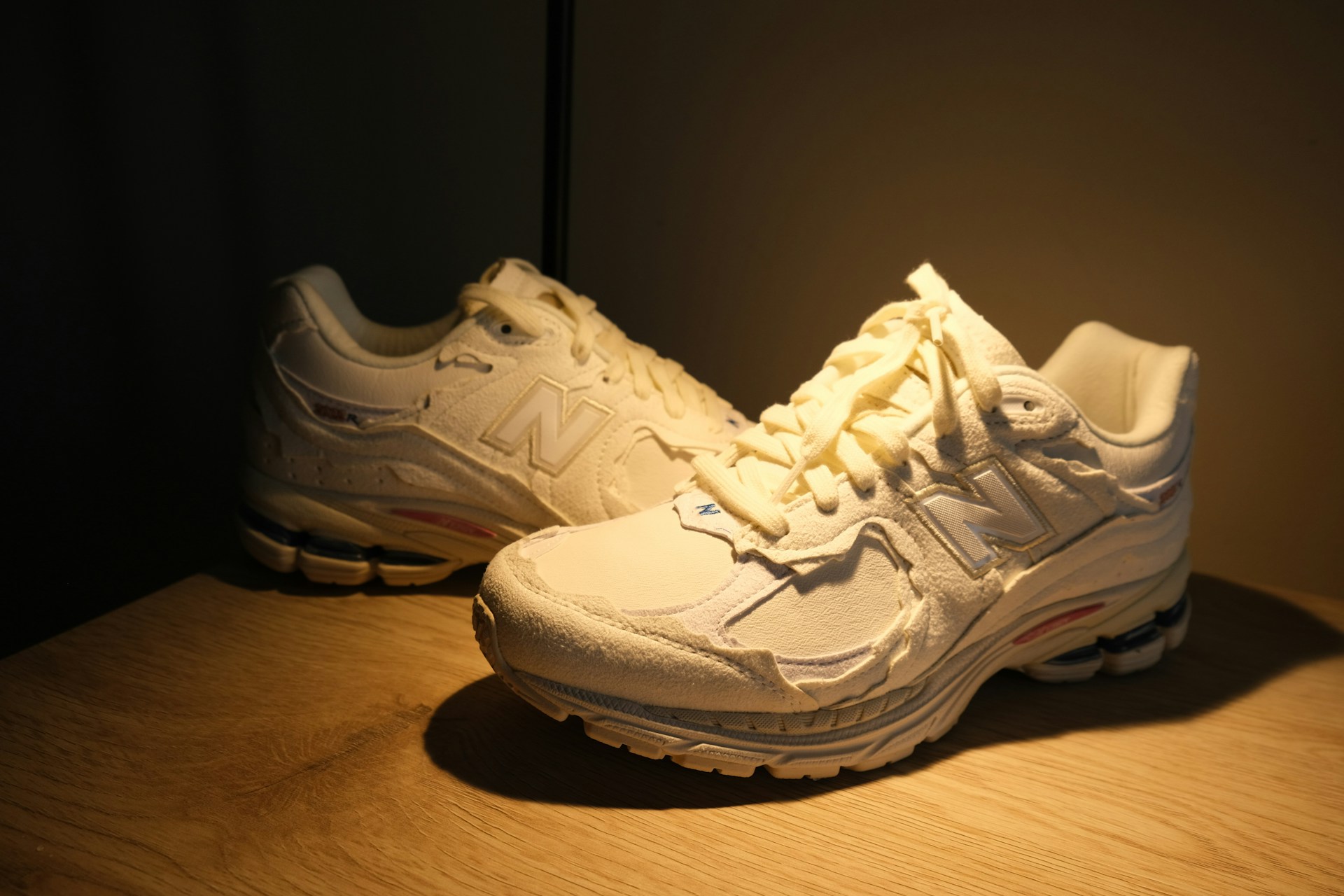 A stylish pair of shoes displayed on a wooden table with soft natural light.