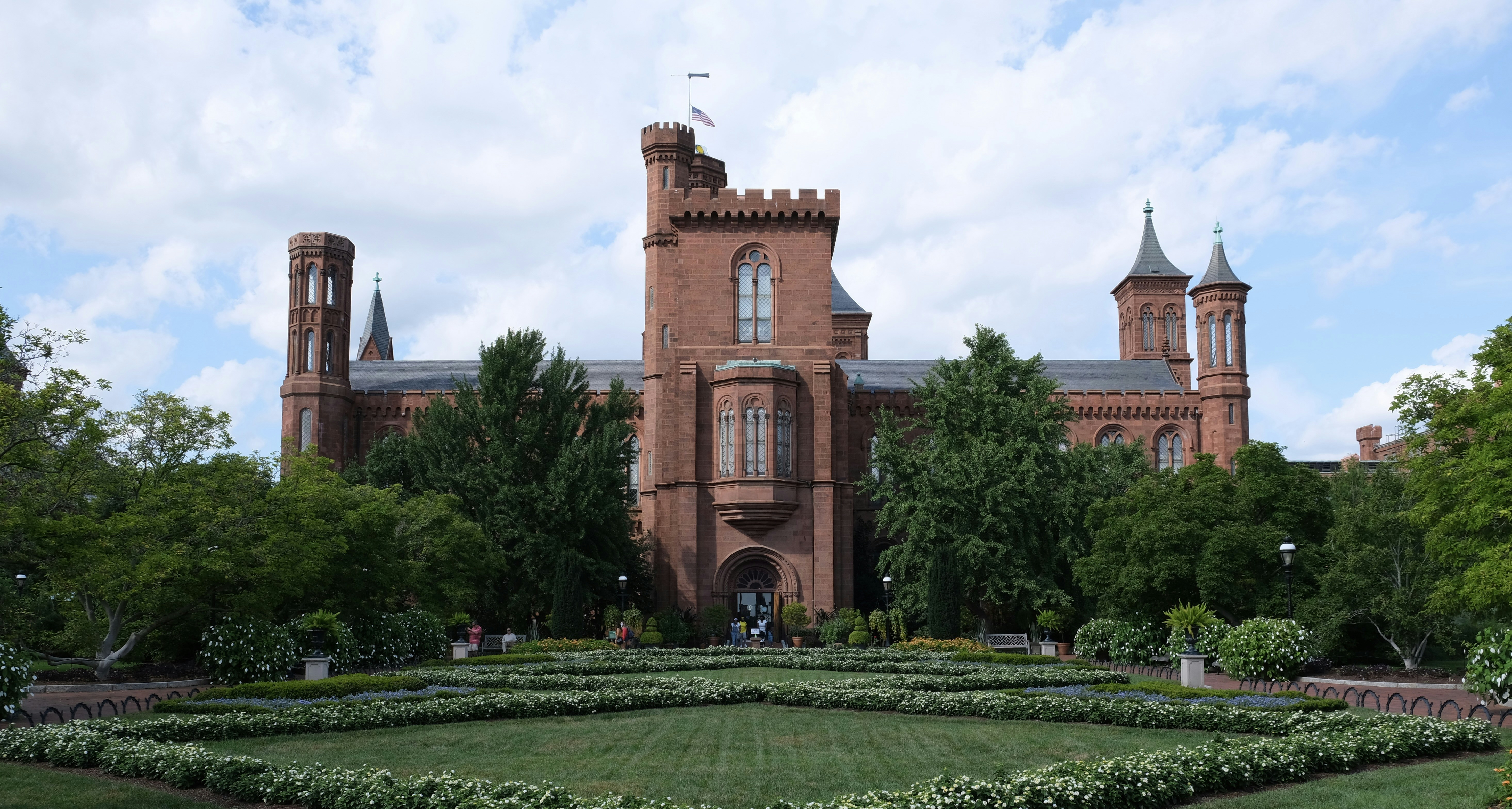 a large brick building with a garden in front of it