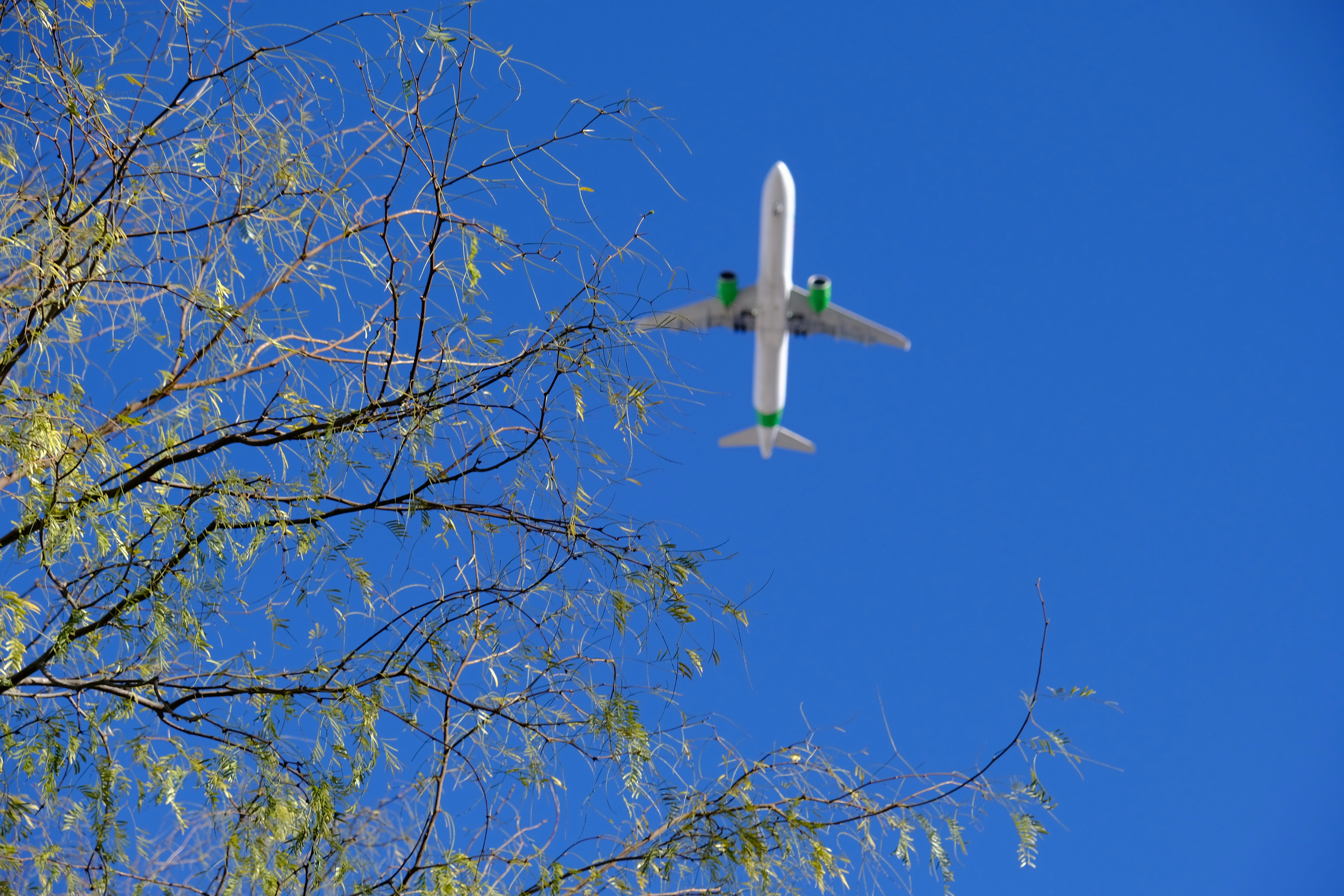 an airplane is flying in the blue sky, 