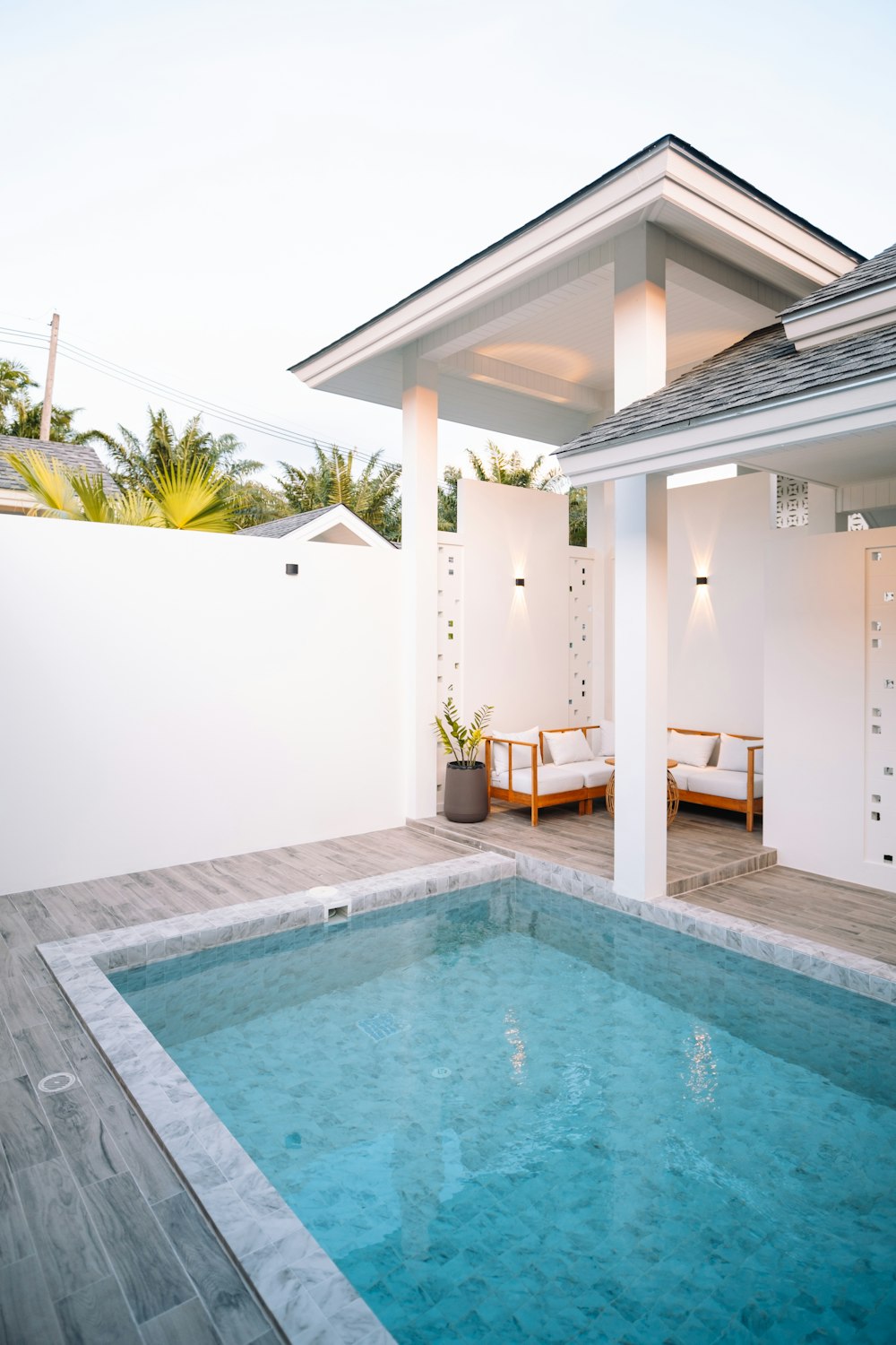 a swimming pool with a white house in the background