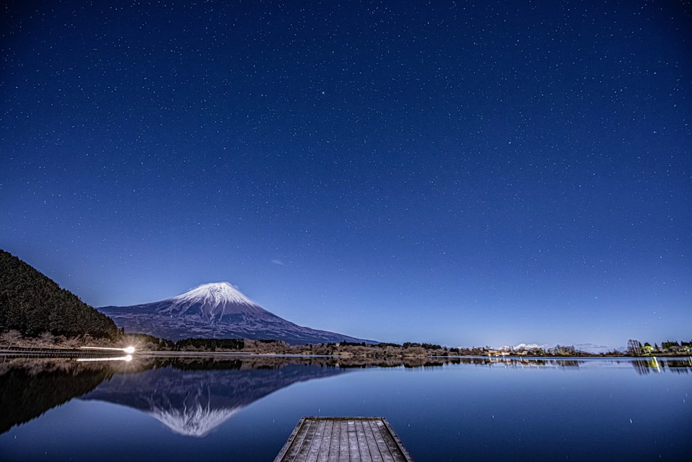 a night view of a lake with a mountain in the background