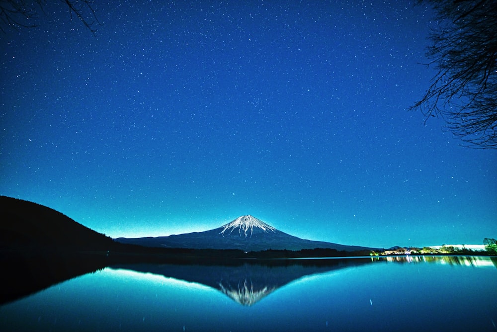 a lake with a mountain in the background at night