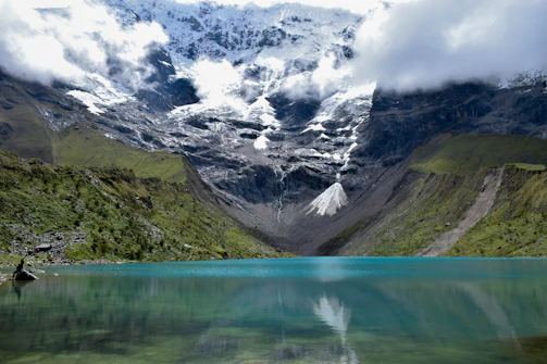 A serene alpine lake with turquoise waters reflecting snow-capped peaks under a clear sky.