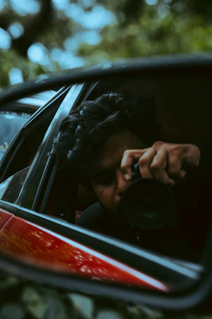 a man taking a picture of himself in a rear view mirror