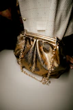 Chic crossbody bag with gold chain strap against a sleek black background