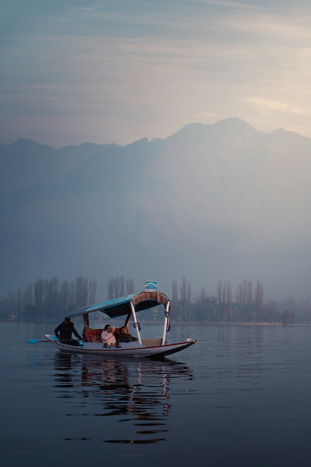 a man on a boat in the middle of a lake