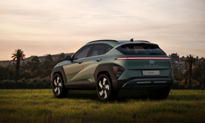 a green suv parked in a grassy field