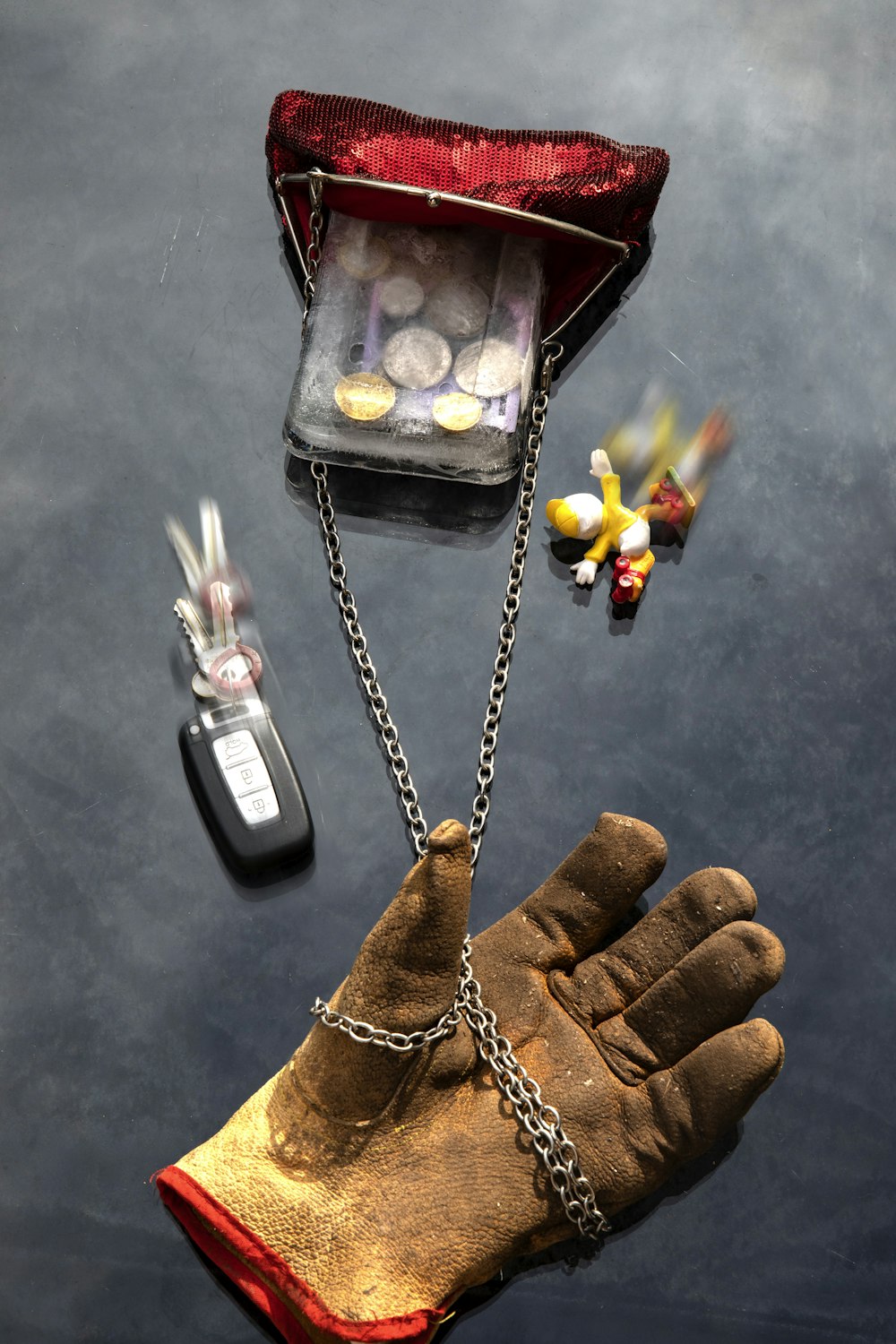 a glove with a chain attached to it next to a bag of pills