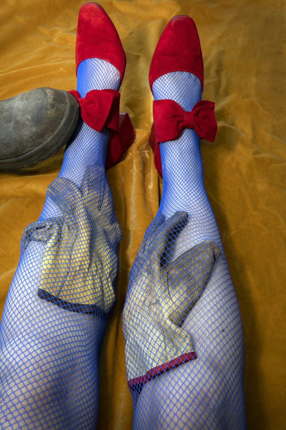 a pair of feet wearing red shoes and blue mesh stockings
