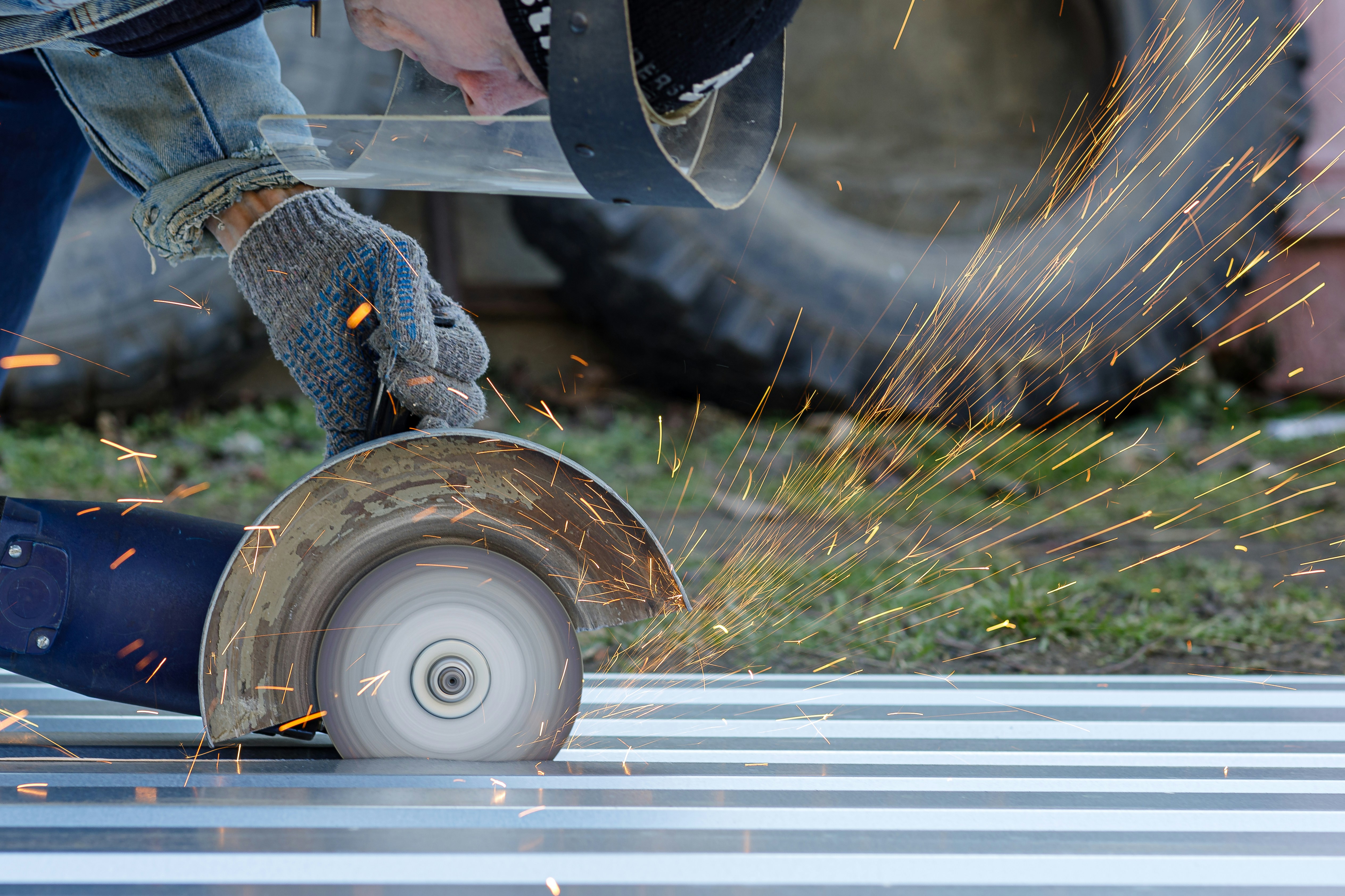 a man grinds a piece of metal with a grinder