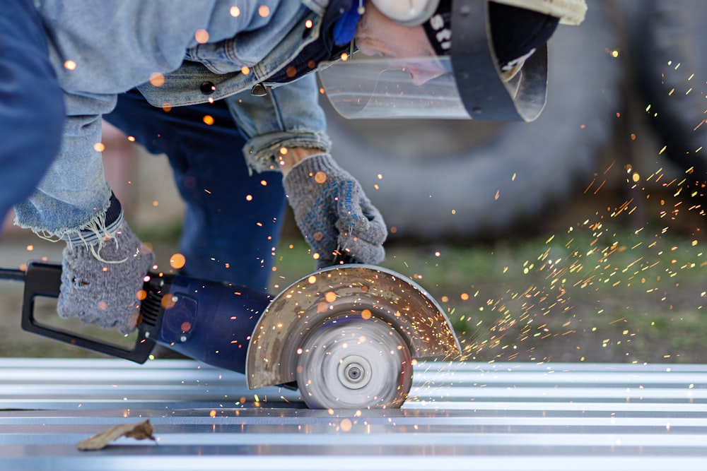 a person using a circular saw to cut metal