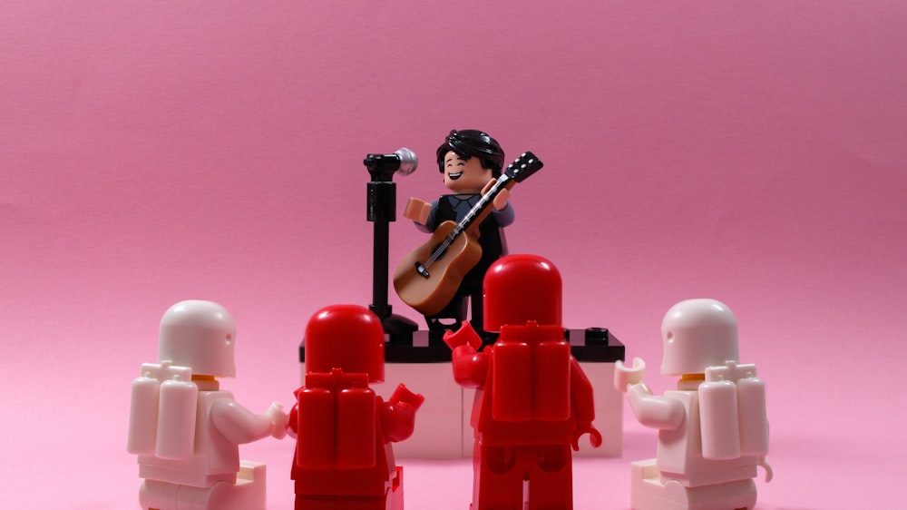 a lego figure with a guitar and a group of people