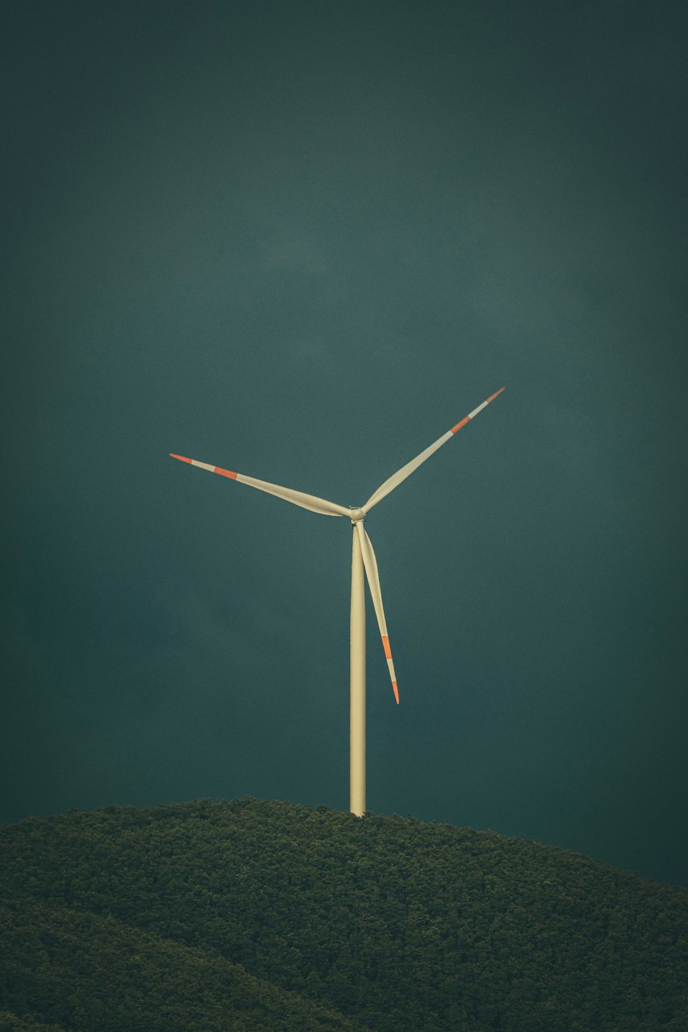 a wind turbine on top of a hill