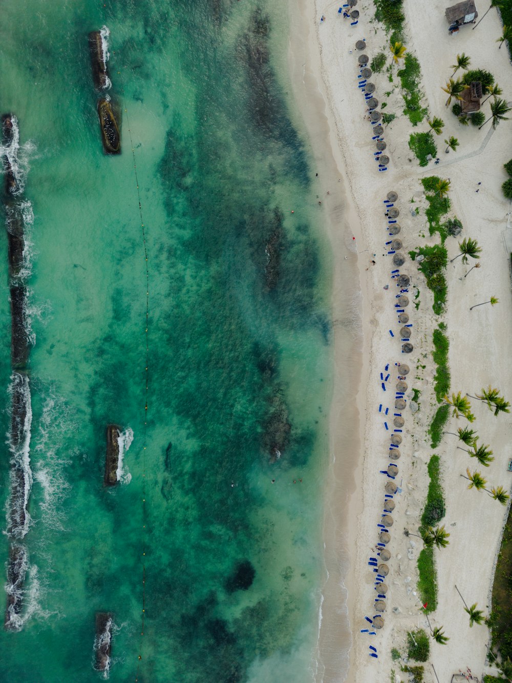 an aerial view of a beach with boats in the water