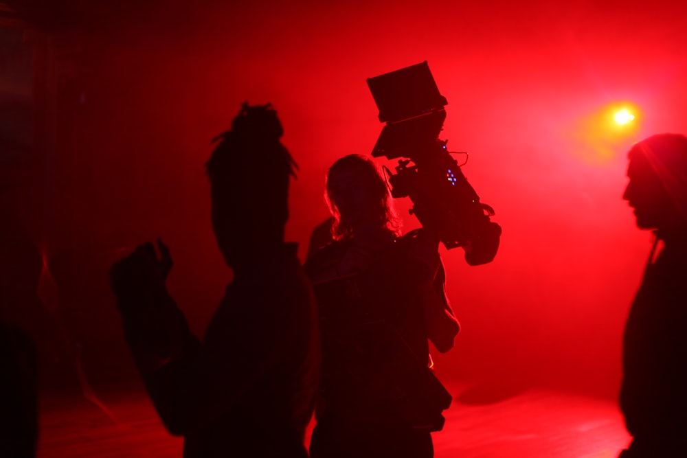 a group of people standing in front of a red light