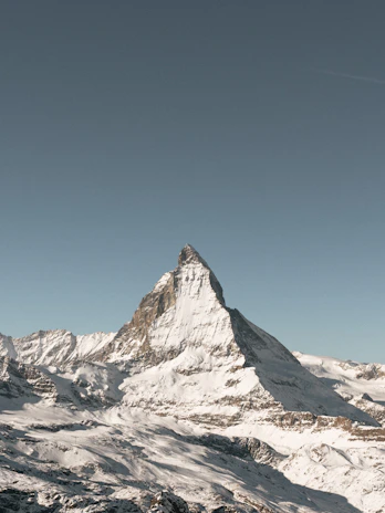 Snow-capped Mount Temple peak rising sharply against a crisp charcoal sky at dawn.