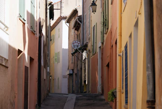 a narrow alley way with a clock on the wall