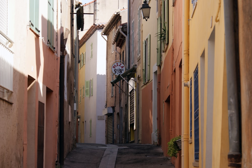 a narrow alley way with a clock on the wall