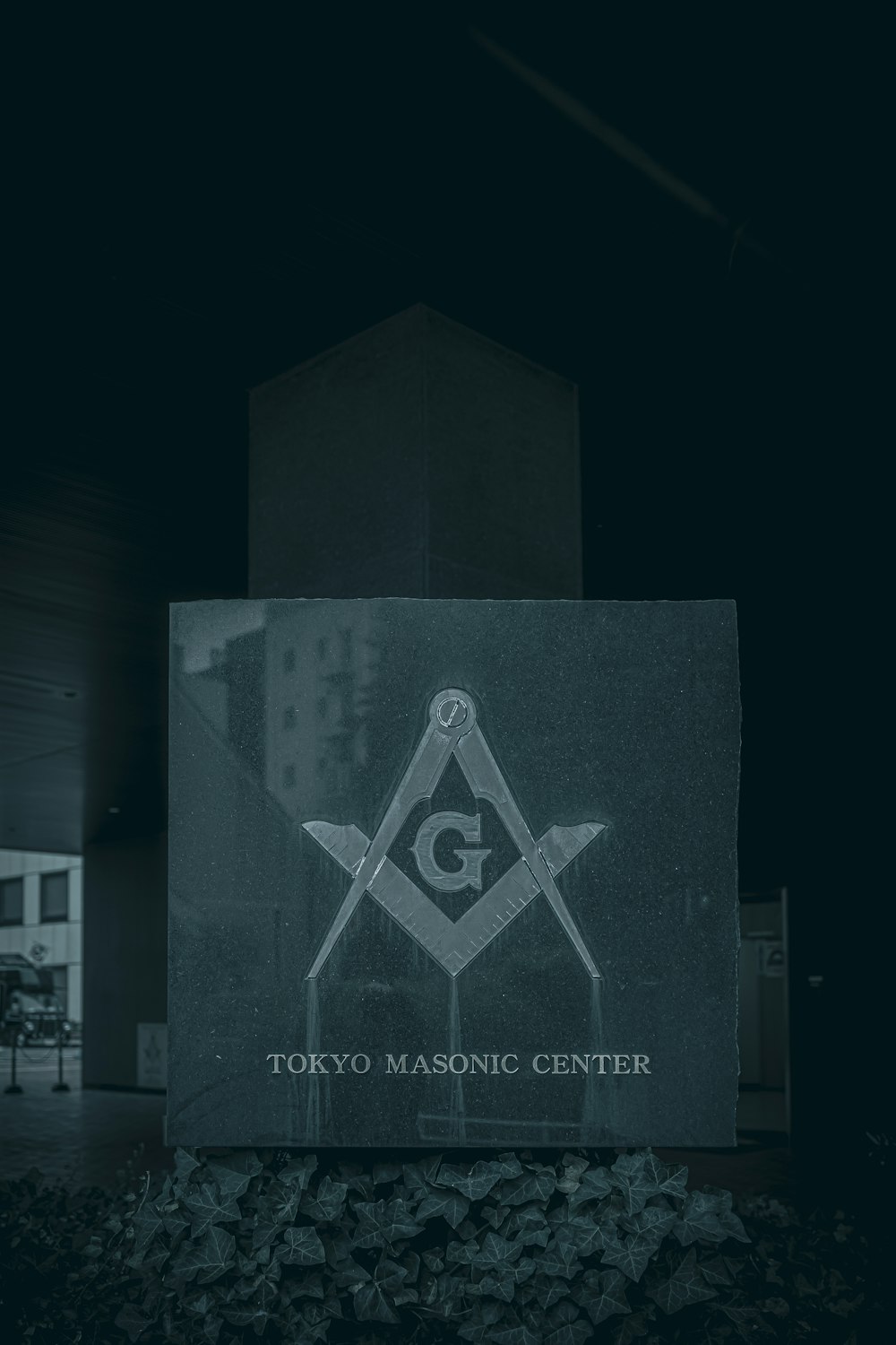 a black and white photo of a building with a sign that says tokyo masonic center