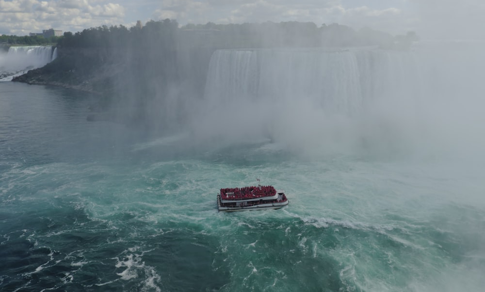 a boat in a body of water near a waterfall