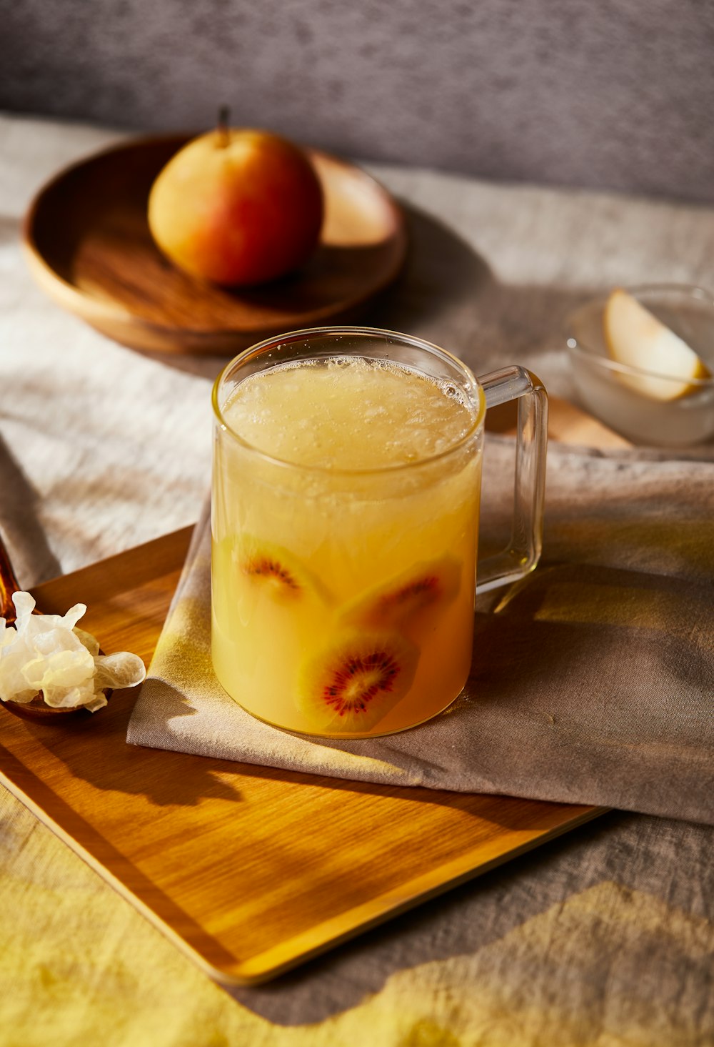 a pitcher of liquid sitting on top of a wooden cutting board