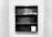 A black wooden shelf is mounted on a tiled wall. The shelf has three compartments with a hanger and a toothbrush on the middle shelf, while a roll of toilet paper is placed on the bottom shelf. The surrounding walls are covered in pale, textured tiles.