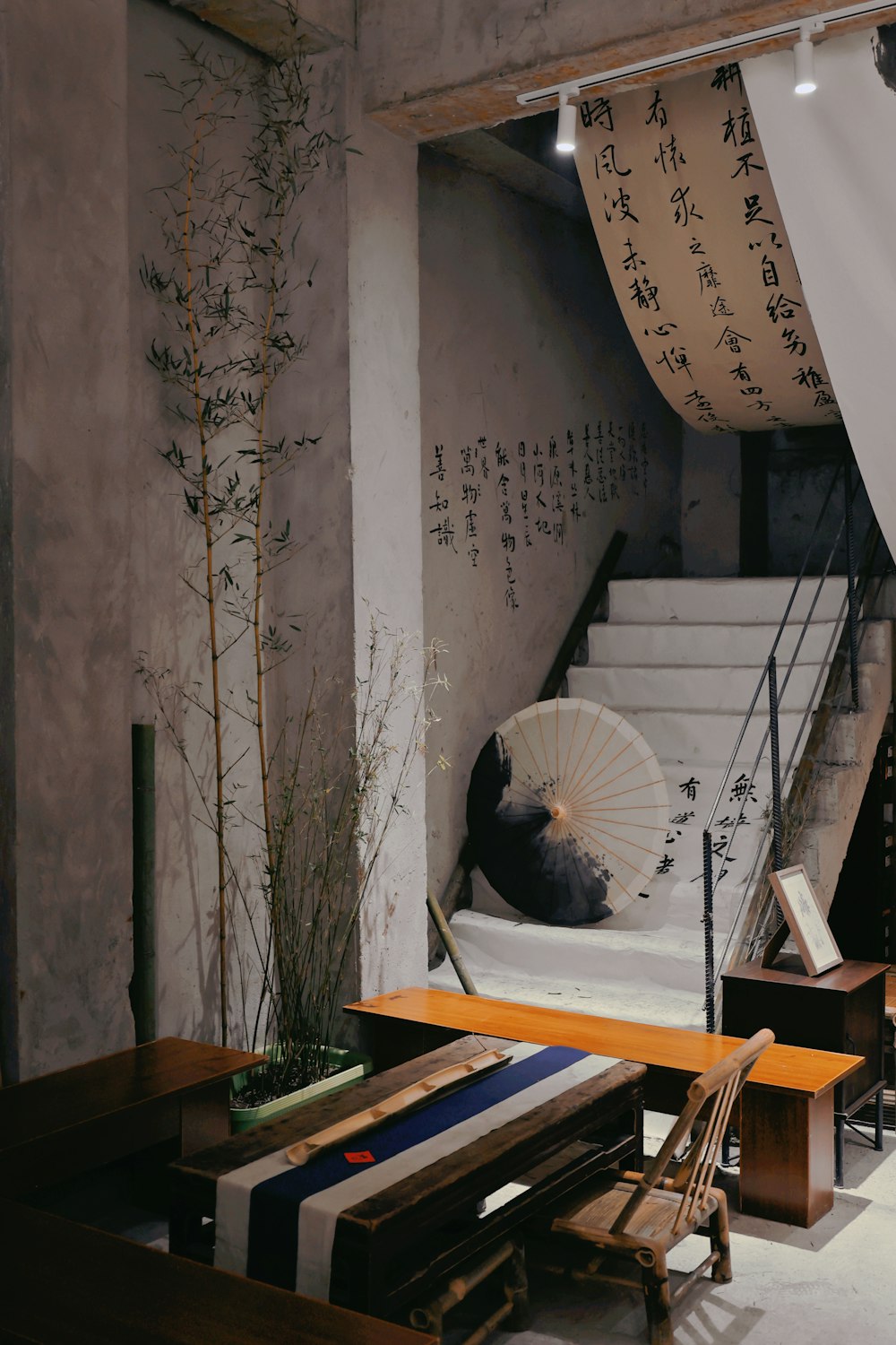 a room with a table, chair, and umbrella in it