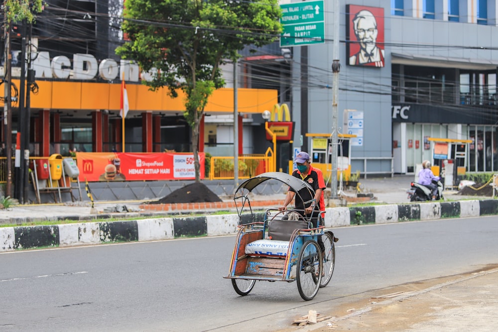 a man riding a bike with a cart attached to it