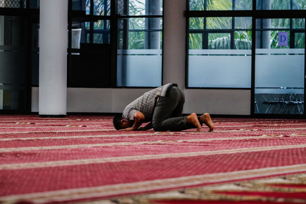 a person kneeling down on a rug in a room