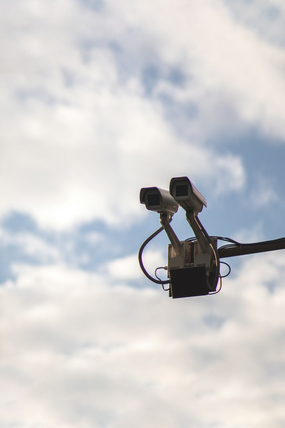 eine Kamera, die an einem Mast vor einem bewölkten Himmel befestigt ist