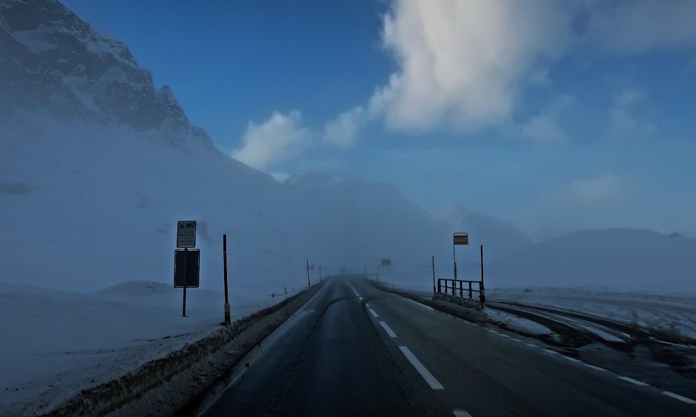 a snowy road with a mountain in the background