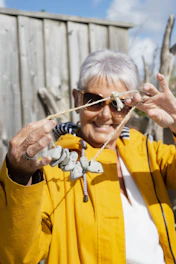 a woman in a yellow jacket is holding a rope