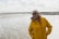 a woman standing on a beach next to the ocean