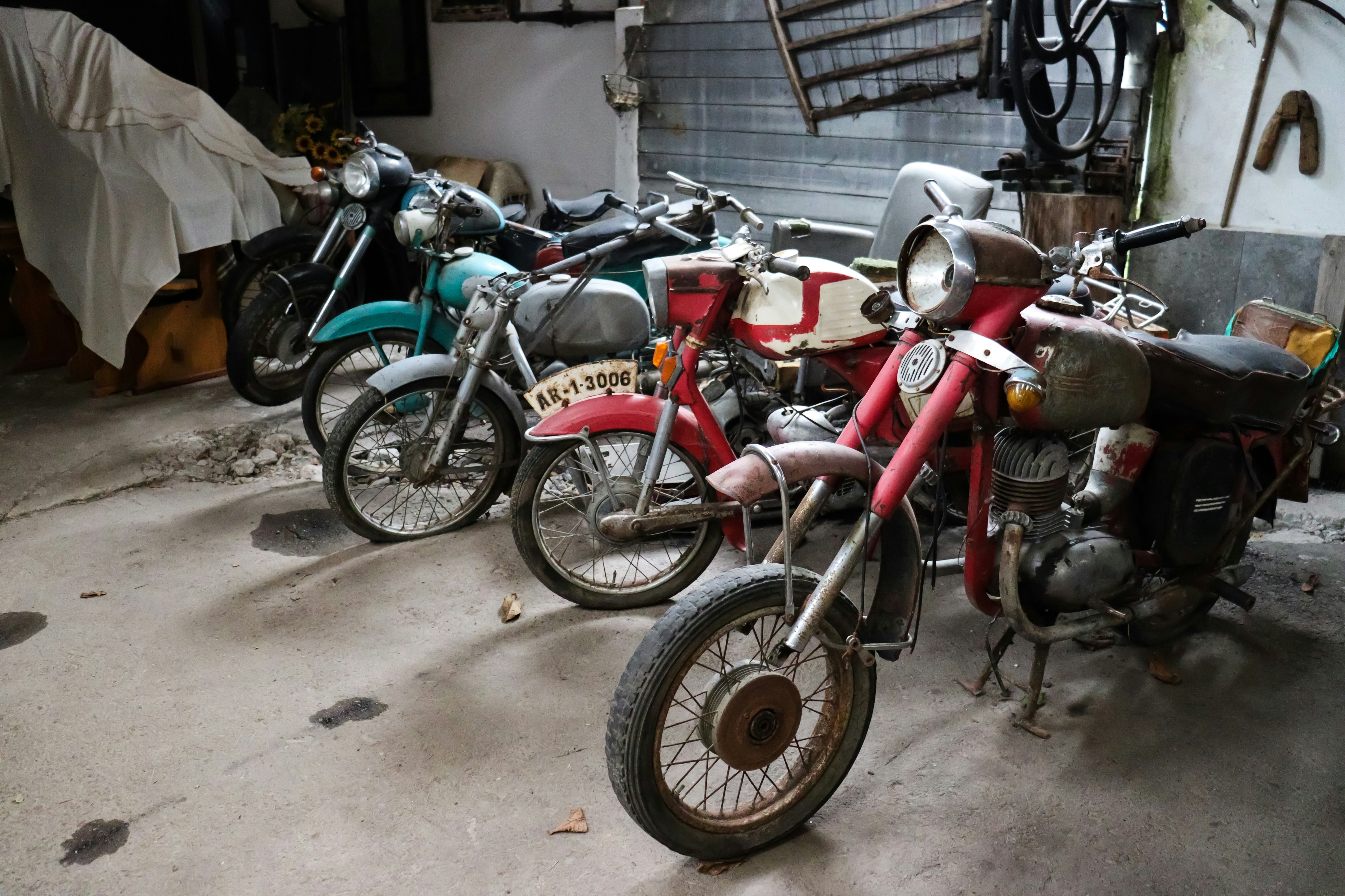 Old motorcycles at an ethnographic museum in Chiscau, Romania showing cluttered storage