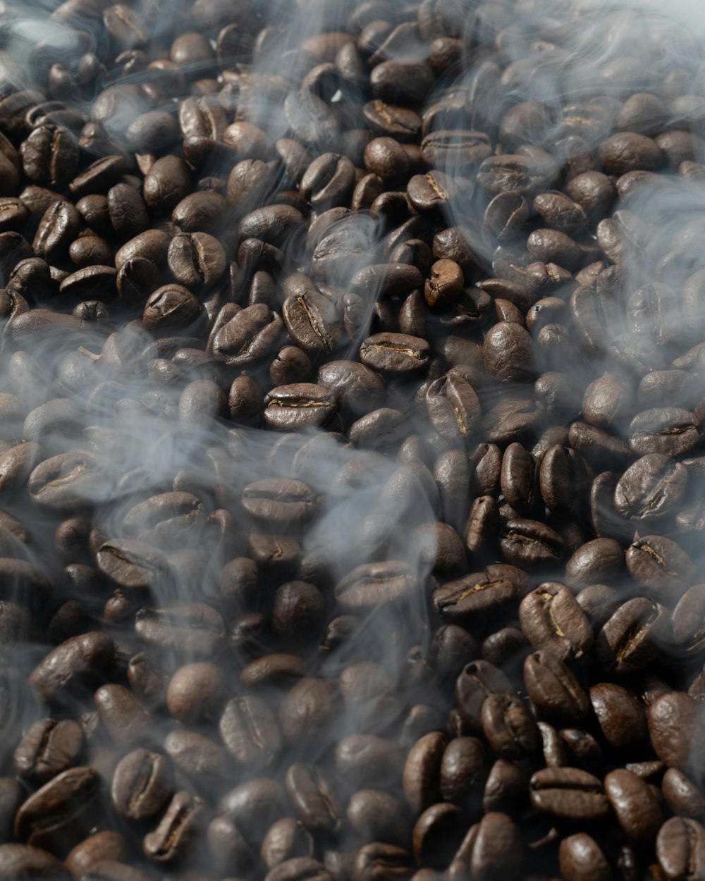 a pile of coffee beans with smoke coming out of them