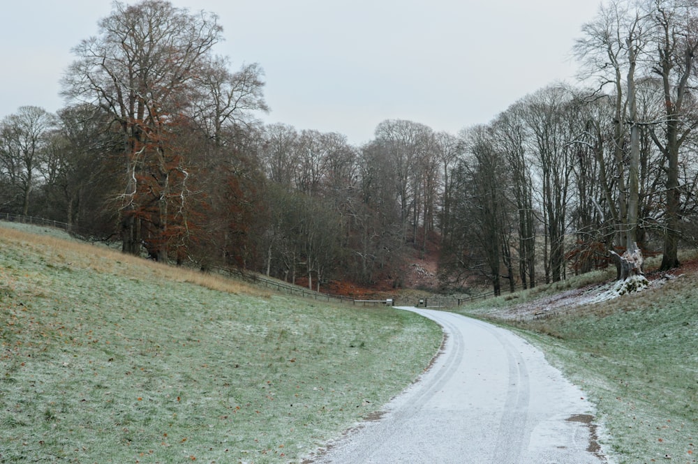 a snow covered road in the middle of a field