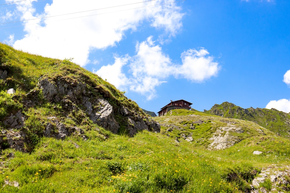 a grassy hill with a house on top of it